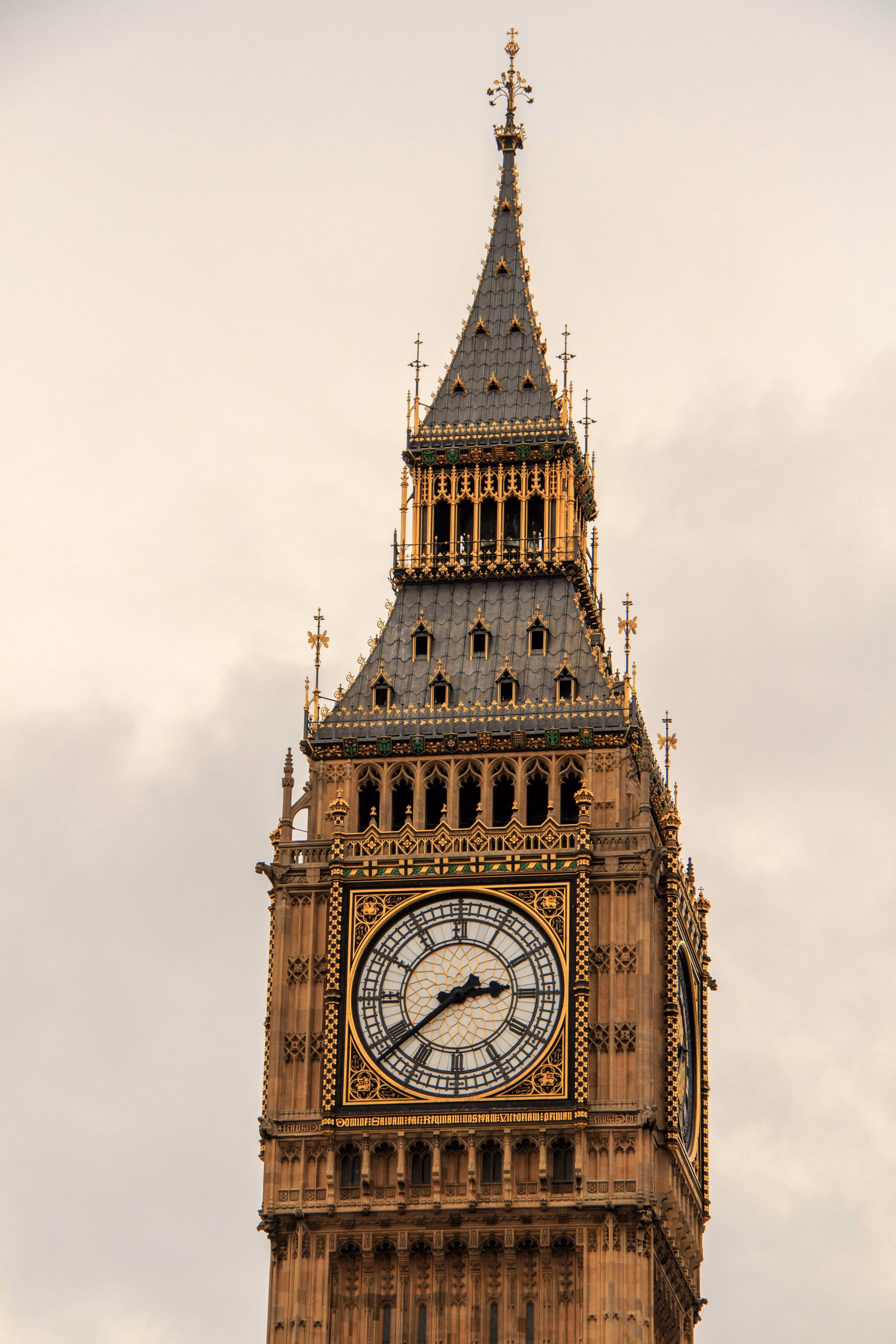 Close-up of Big Ben clock tower with detailed Gothic architecture under a cloudy sky.