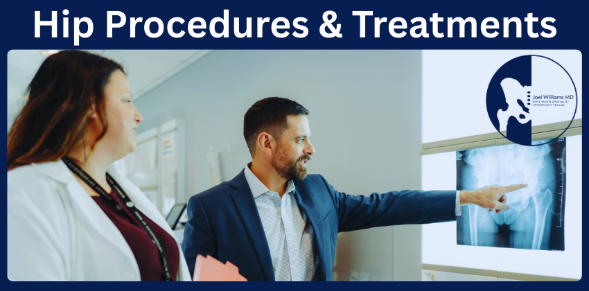 Dr. Joel Williams in a suit points to a hip X-ray on a lightbox while talking to a female colleague in a white coat.