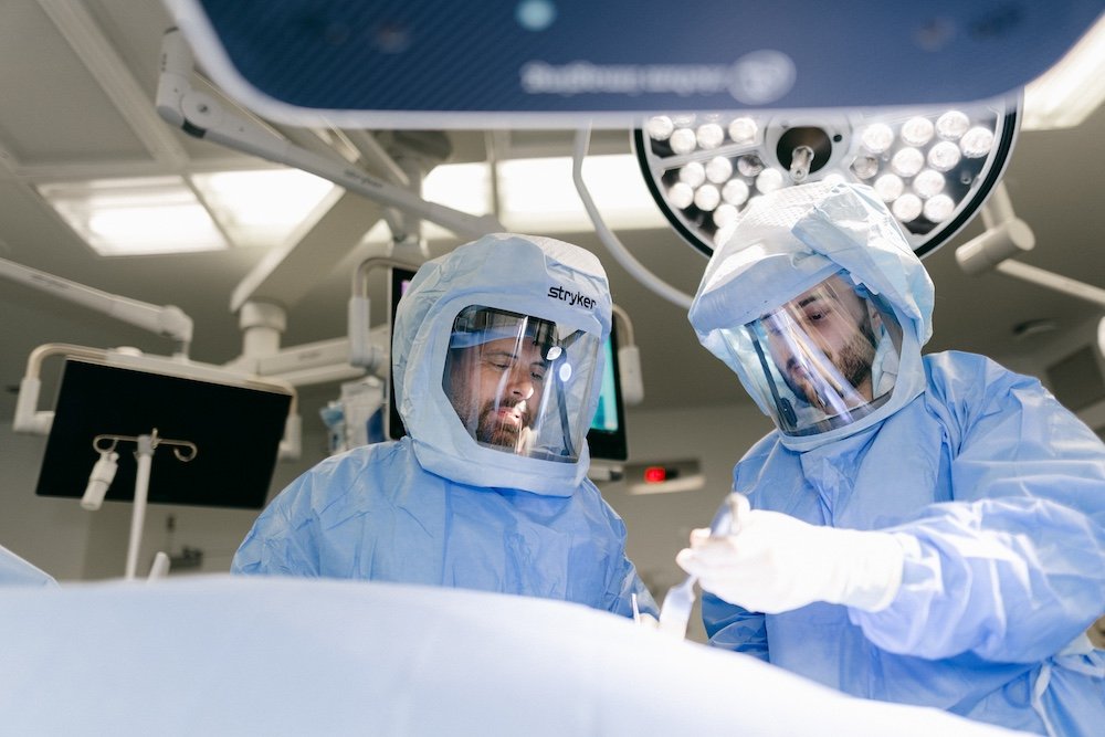 Dr. Joel Williams with a fellow surgeon on the operating table