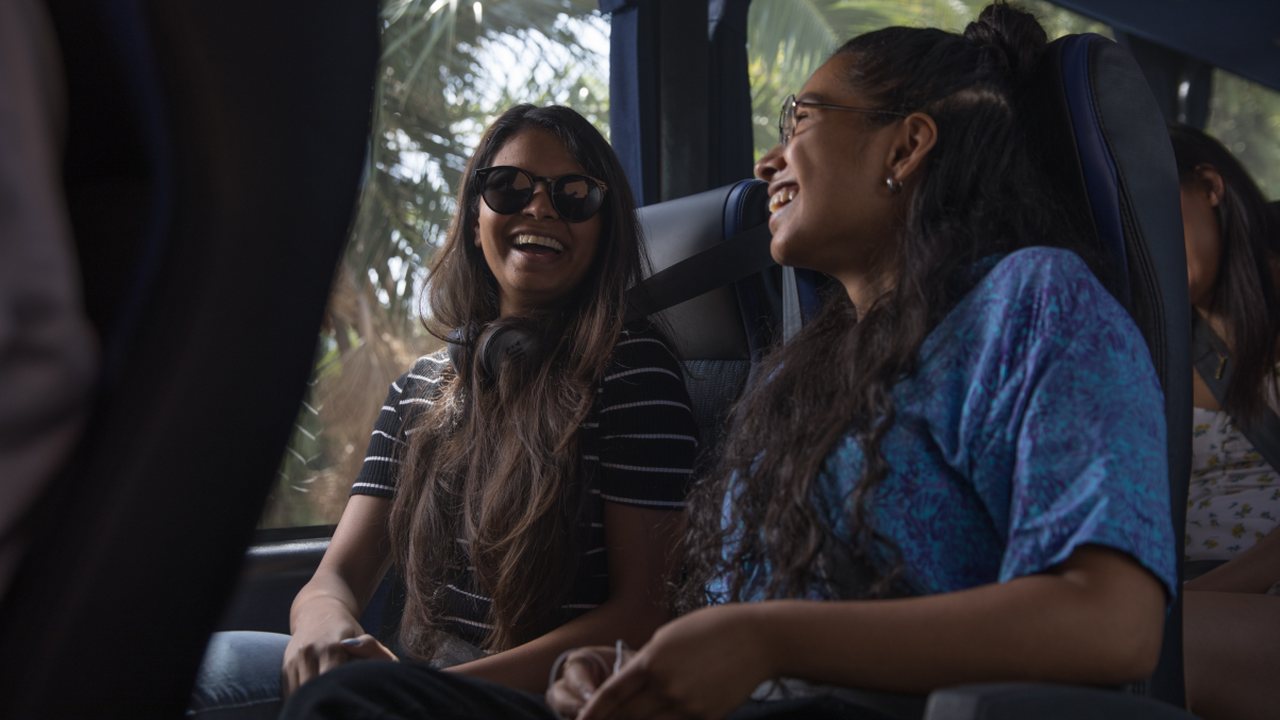 Two passengers laughing together on board a Firefly coach