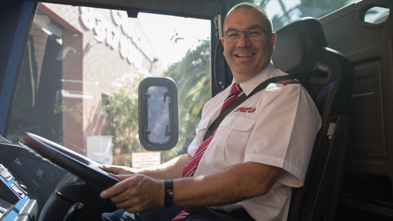 A Firefly Express driver at the wheel of a coach