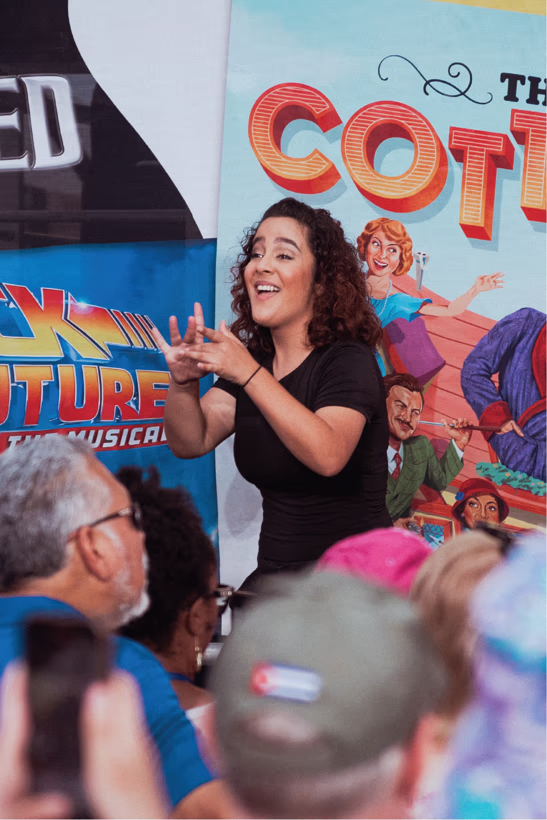 A woman is singing in front of a crowd of people.