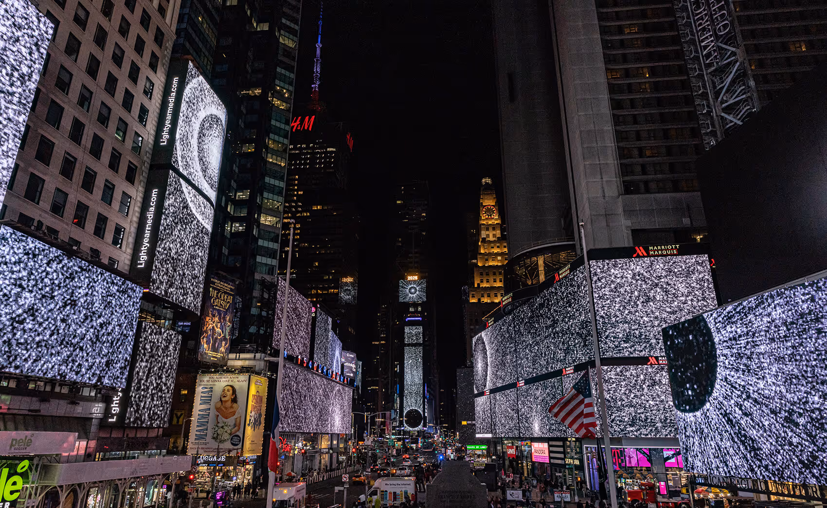 "Pixel Dust" by Leo Villareal on the screens of Times Square at midnight, showing radiating circles of light across a black background