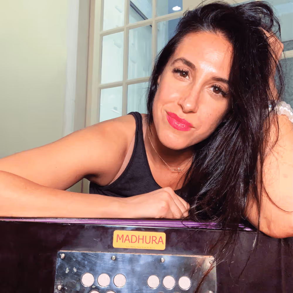 Erica Stanzione, a dark-haired white woman, leaning on her elbows and smirking at the camera