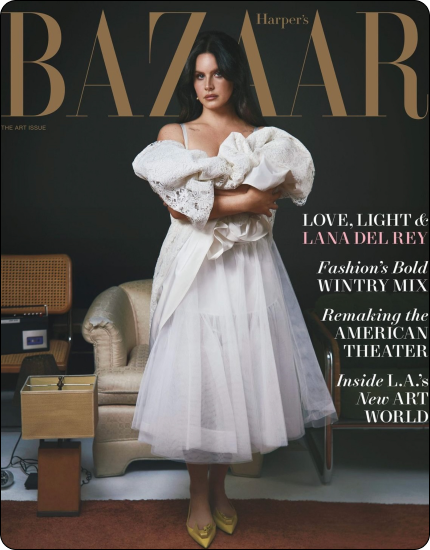 Woman in white lace puff sleeves and tulle skirt stands with arms crossed on Harper's Bazaar cover.