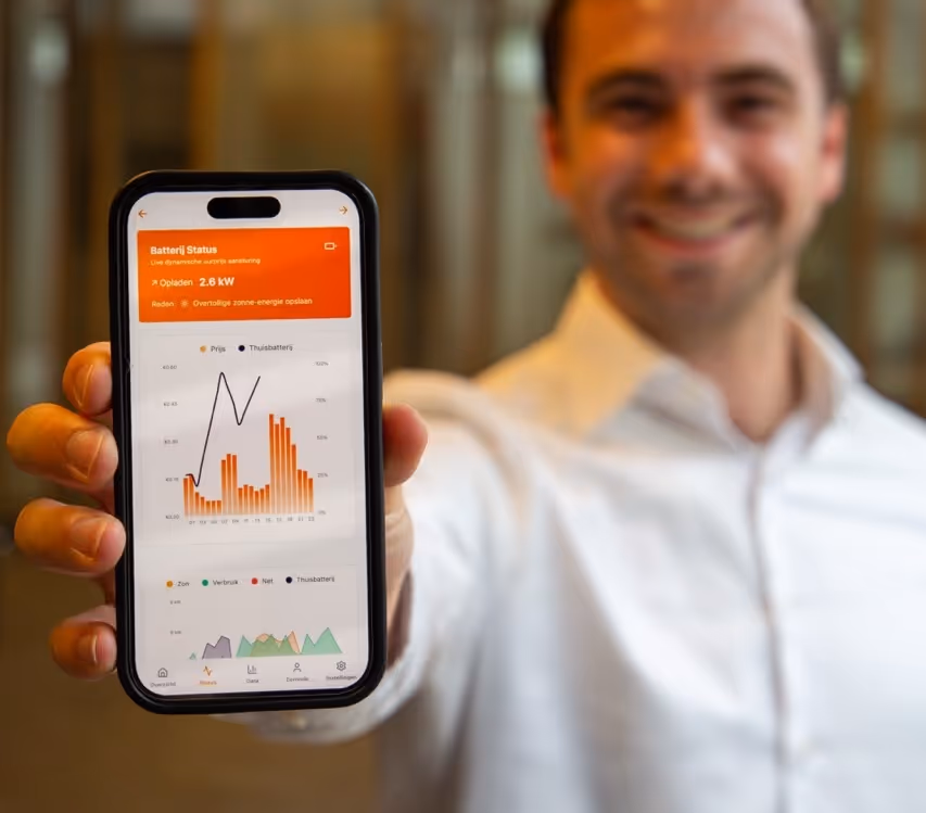 een man die de powerselect app vast houdt met thuisbatterij aansturings data hierop.