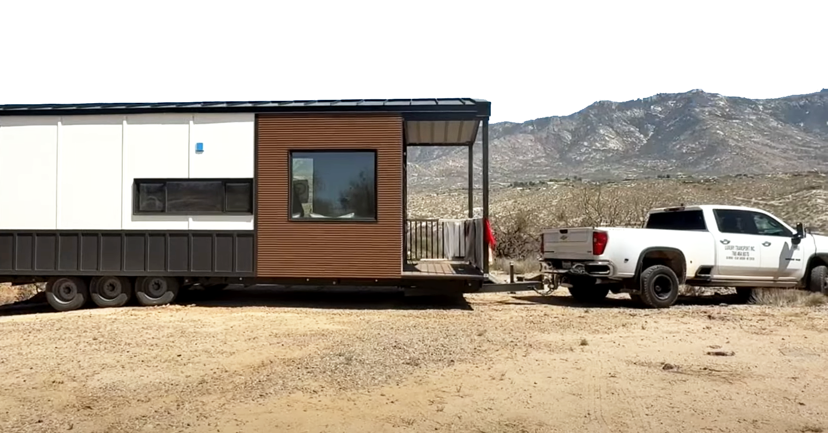 A Clever Tiny Home on Wheels being delivered across rugged terrain by truck.