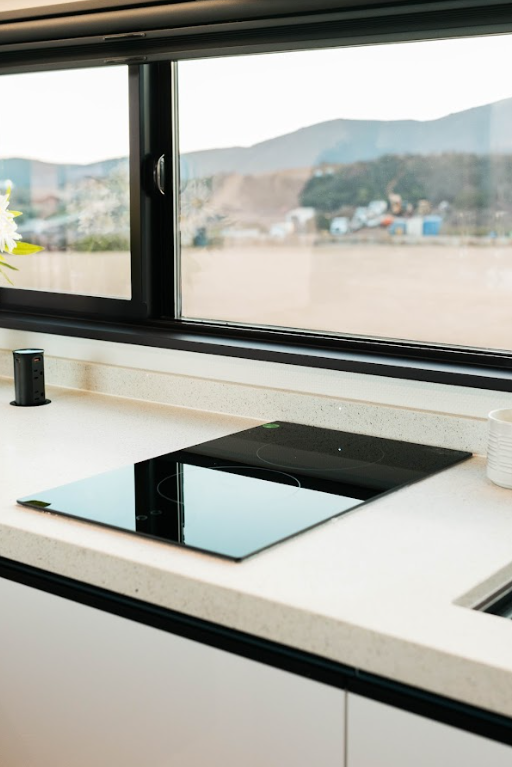 Luxury tiny home kitchen with quartz countertop and induction stove.