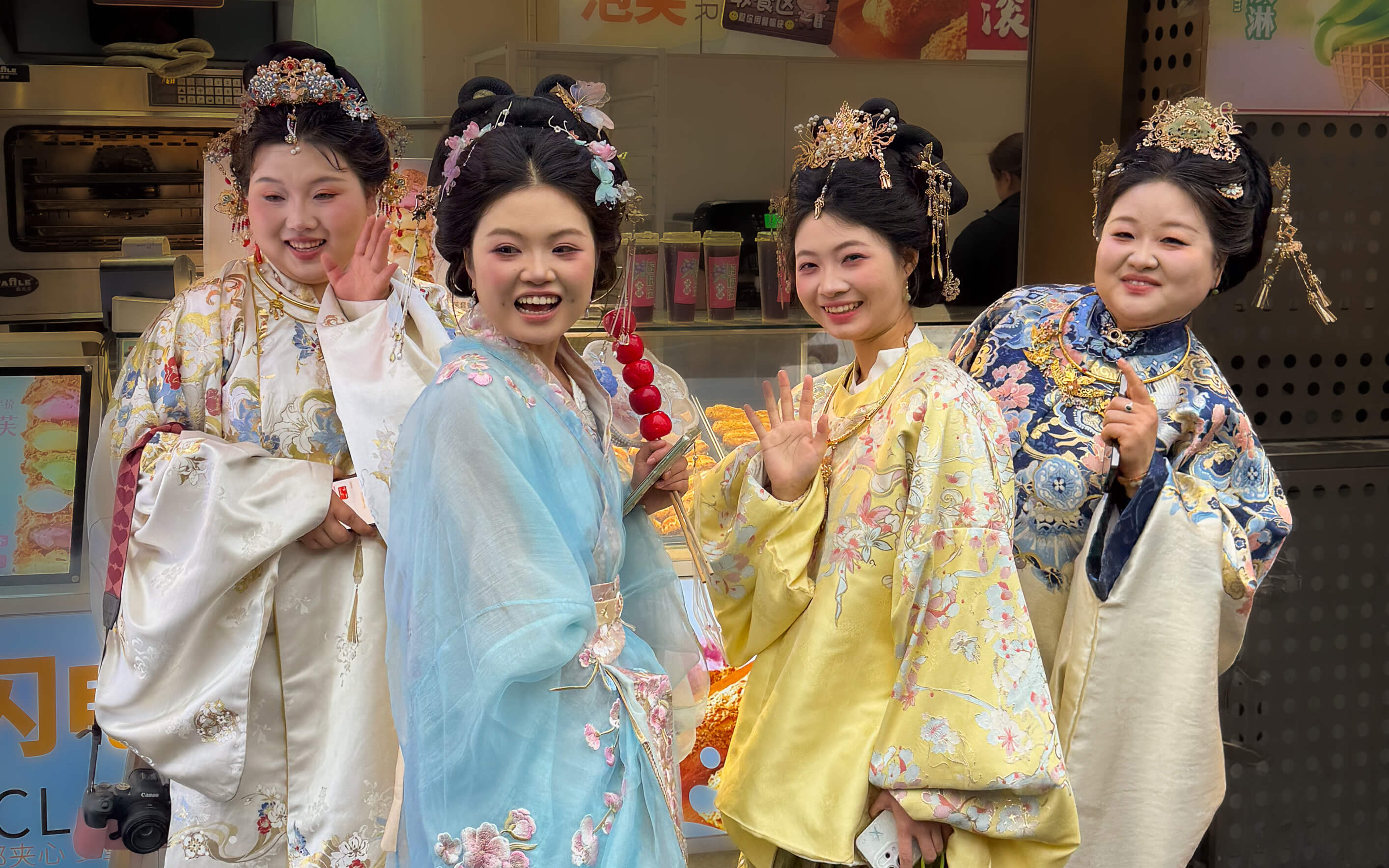 Traditionelle chinesische Kleidung und Haarschmuck: Vier Frauen in bunten Cheongsam-Roben präsentieren historische Qipao-Mode in chinesischem Museum