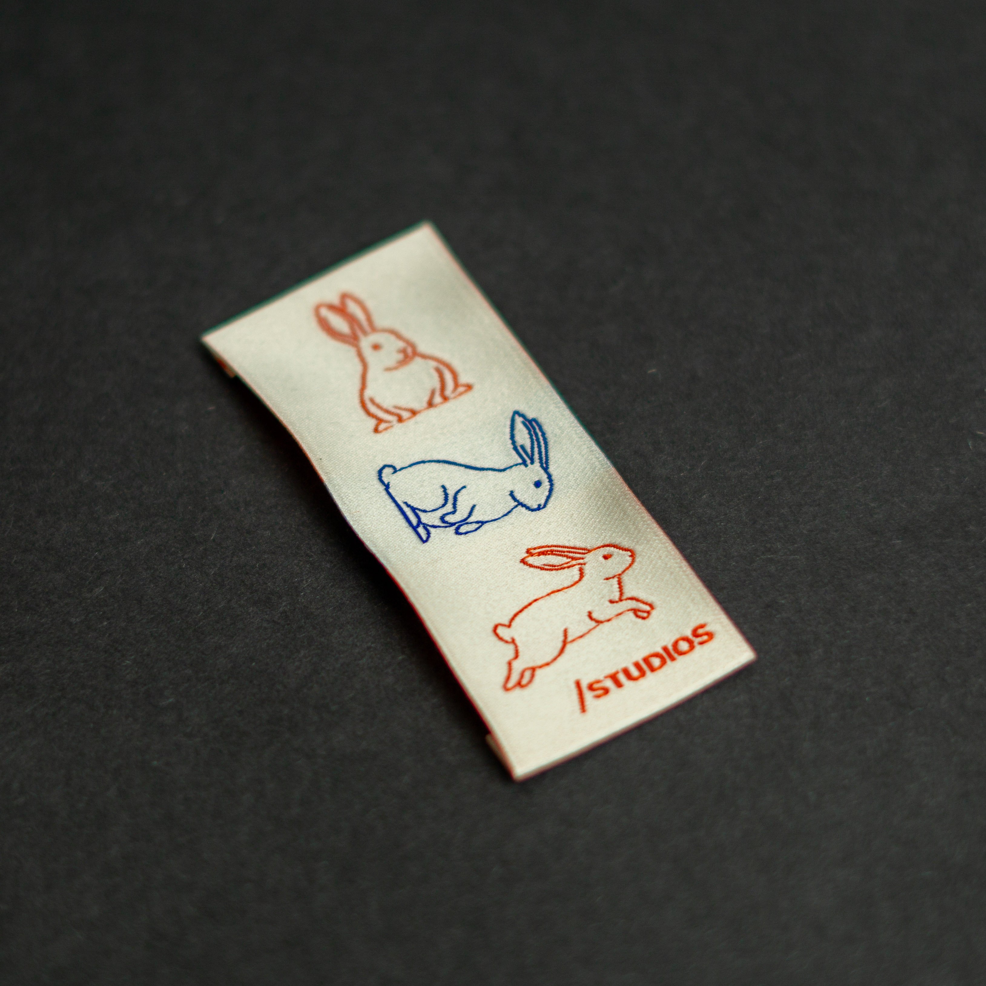 Fine detail woven label with rabbits