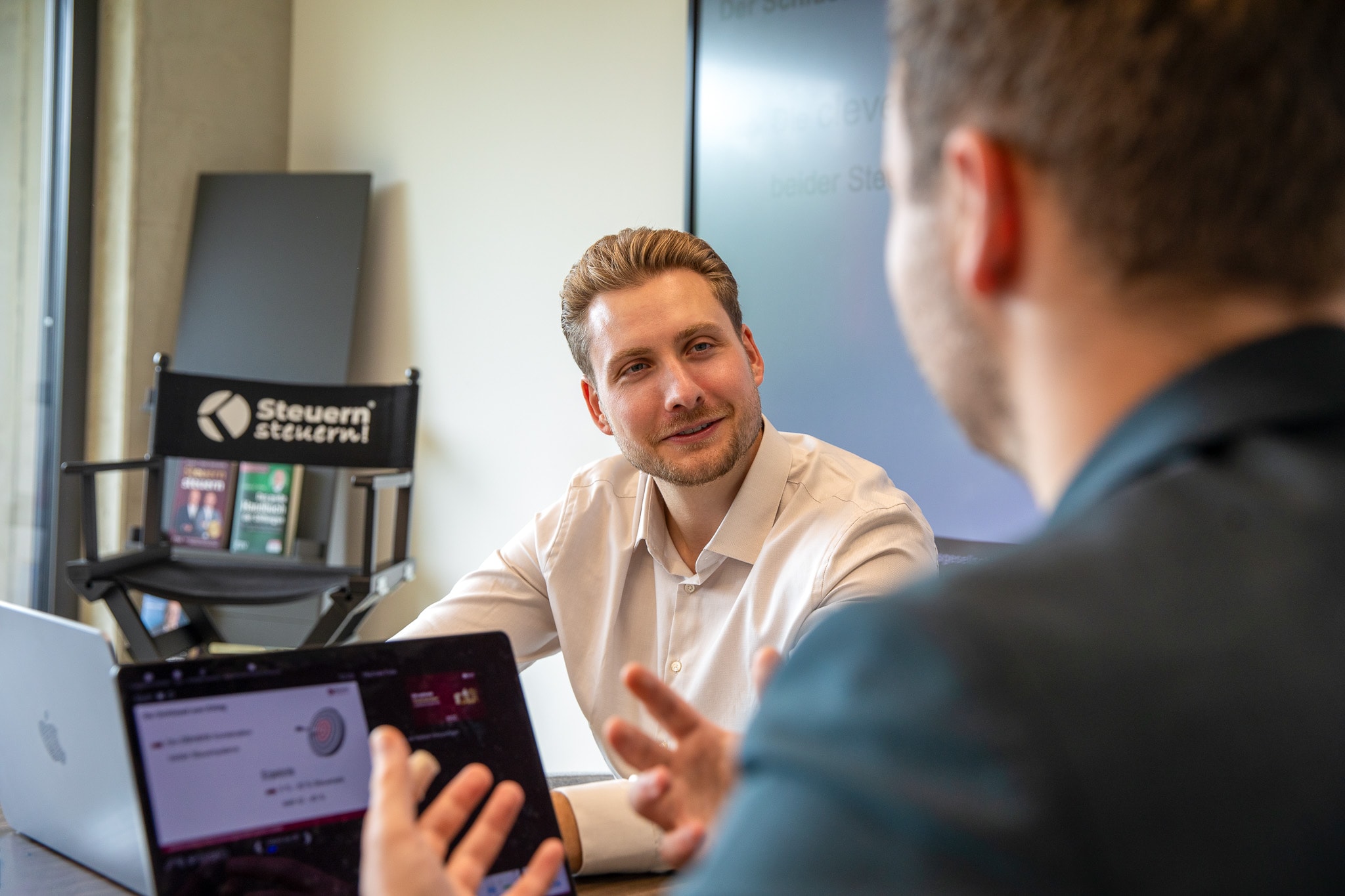Zwei Kollegen diskutieren effektive Steuertipps und Finanzstrategien.