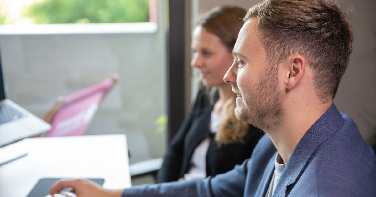 Zwei Nachwuchskräfte arbeiten gemeinsam am Computer und besprechen ihren Weg in die Steuerberater-Karriere.