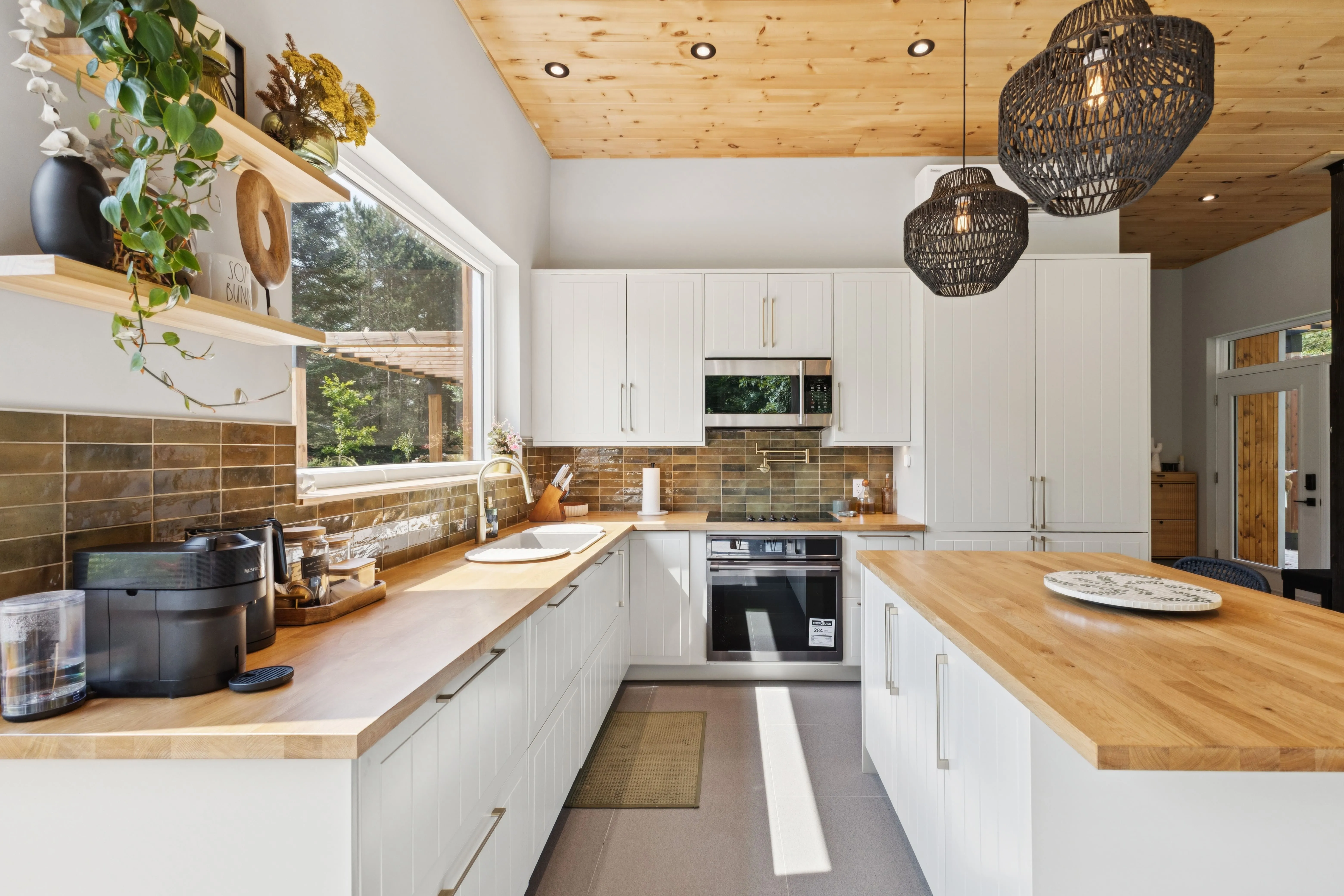 Professional real estate photography of a modern kitchen with wood countertops and a natural wood ceiling, a marketing service by Parsell for property listings in the Gatineau-Ottawa region. | Photographie immobilière professionnelle d'une cuisine moderne 