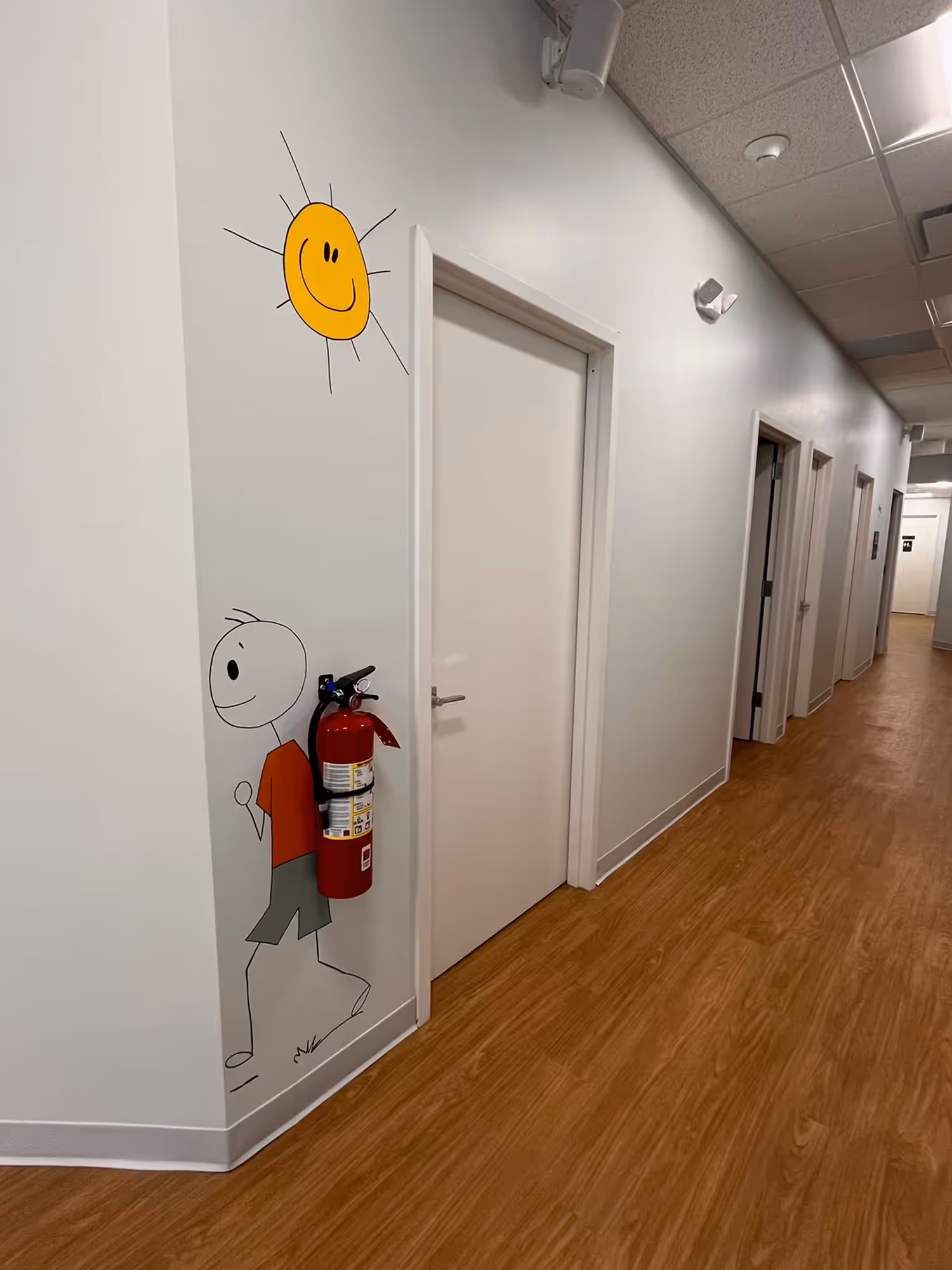 A hallway with a fire extinguisher painted on the wall.