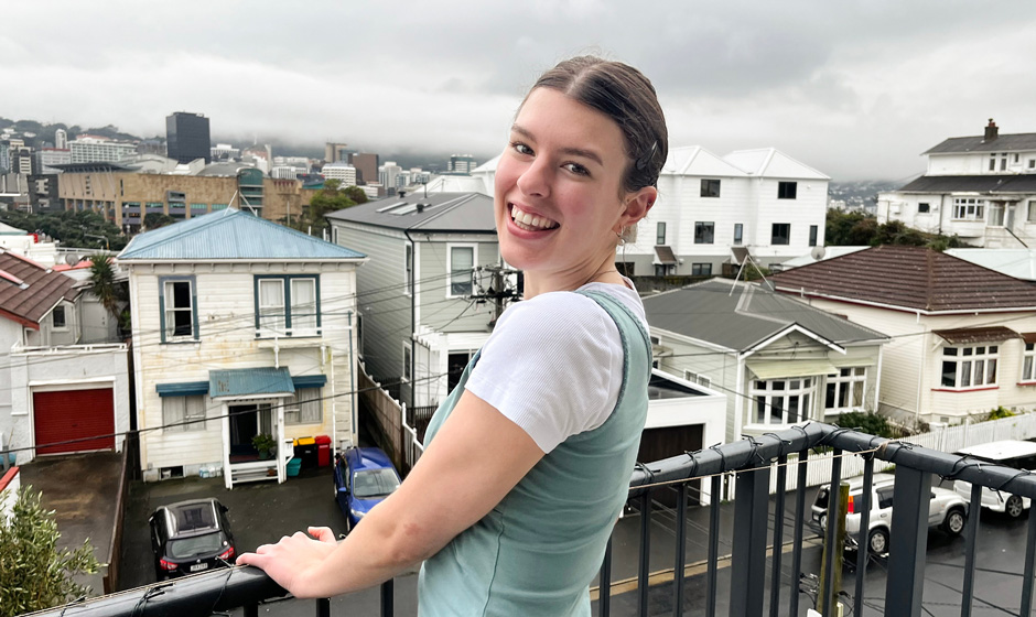 Molly Woodham standing on a balcony overlooking Wellington City.