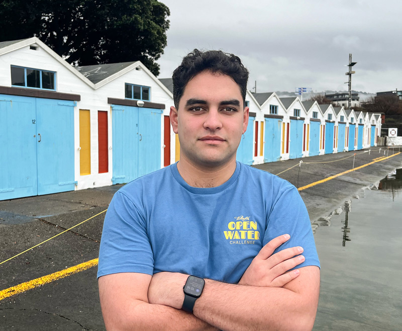 Te Maia Gage-Gray standing in front of the Wellington boat sheds at Oriental Bay.