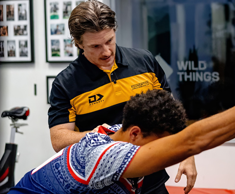 A trainer working with their client in a gym.