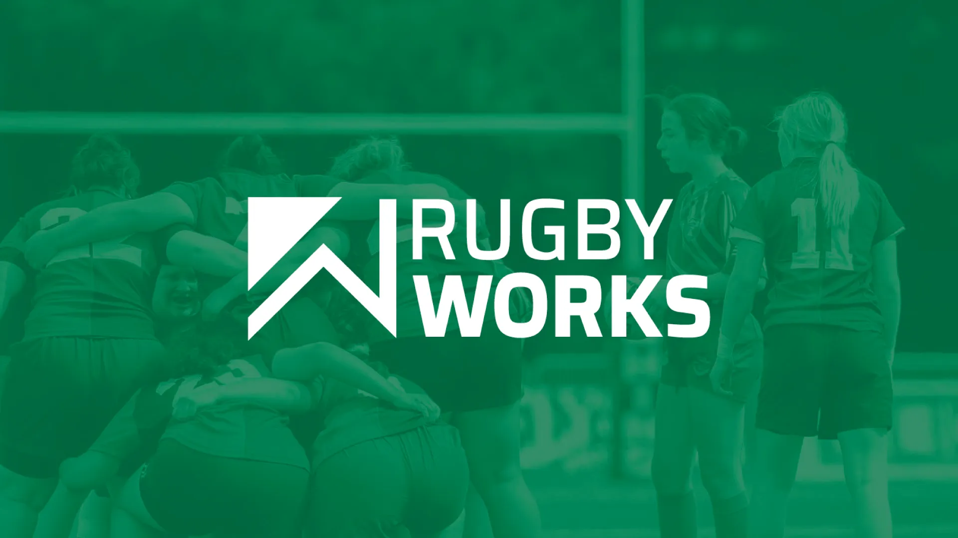 Group of female rugby players huddling on a field with Rugby Works logo overlay.