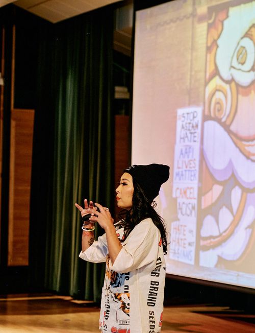 Jackie Nguyen, a Vietnamese American woman, giving a talk on stage at a Creative Mornings event in Kansas City, MO