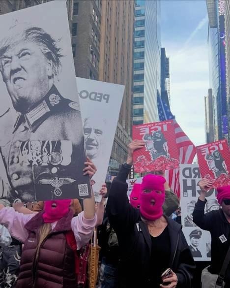 A group of people holding signsAI-generated content may be incorrect.