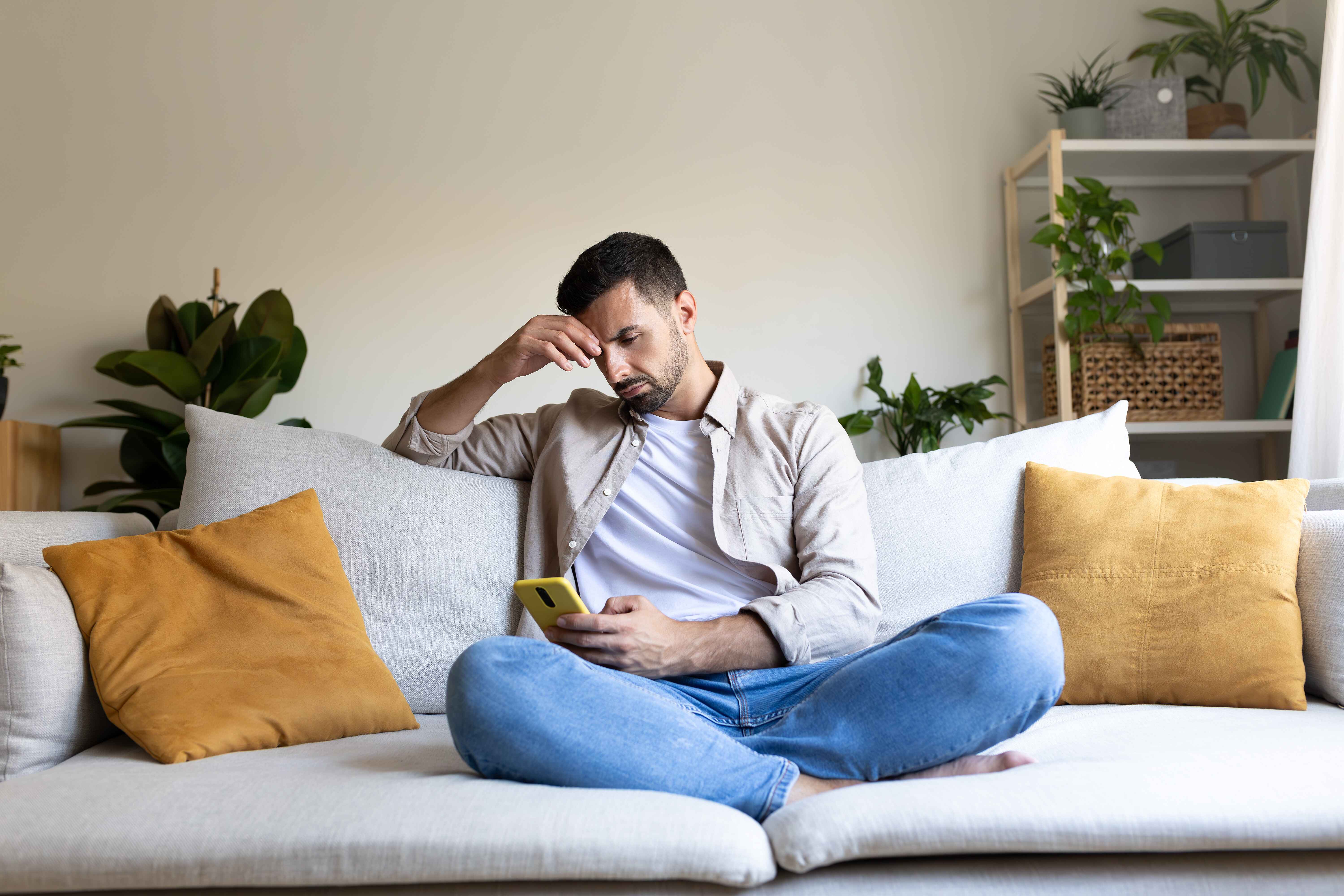Man looking at his phone frustrated