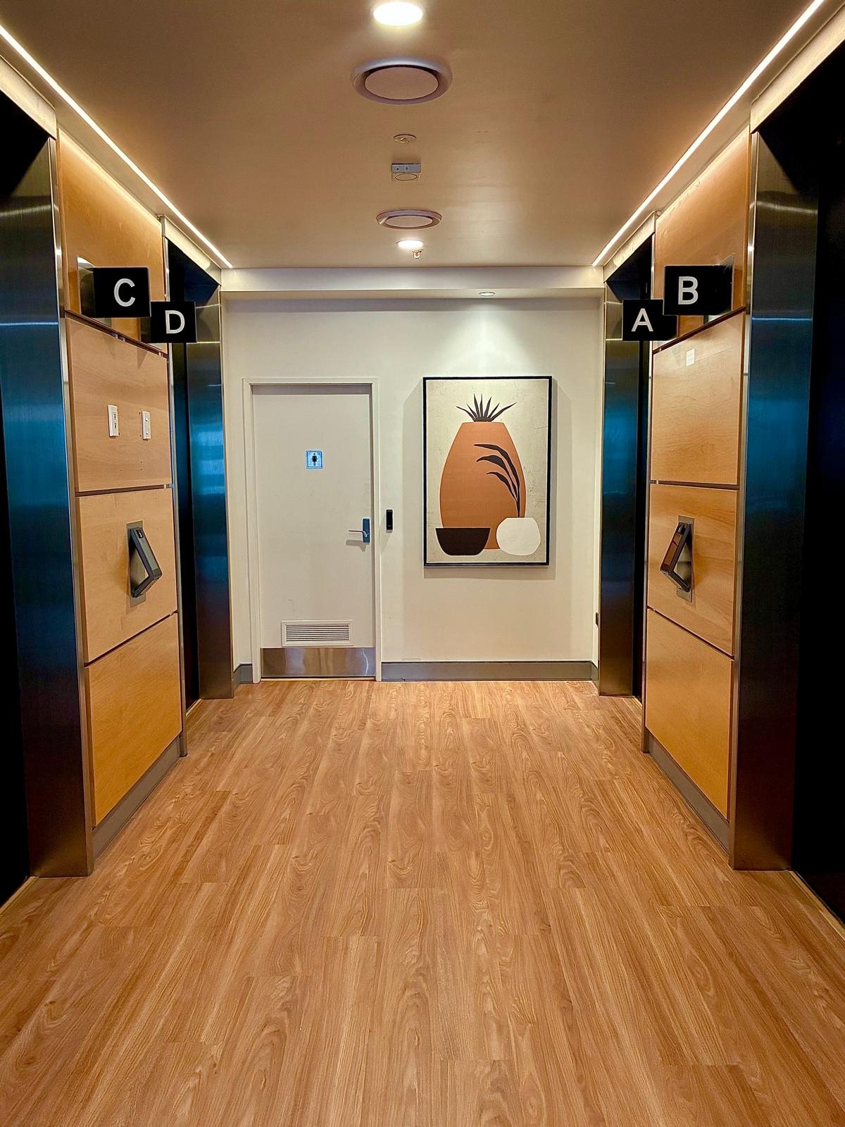 Renovated lift lobby landing with timber floor and timber-lined lift surrounds