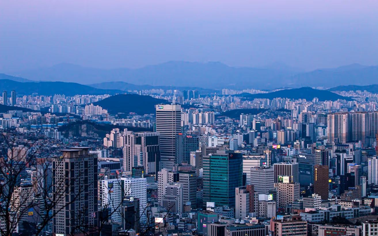 서울 도심 전경 - 석양 무렵 고층 빌딩과 산이 보이는 파노라마