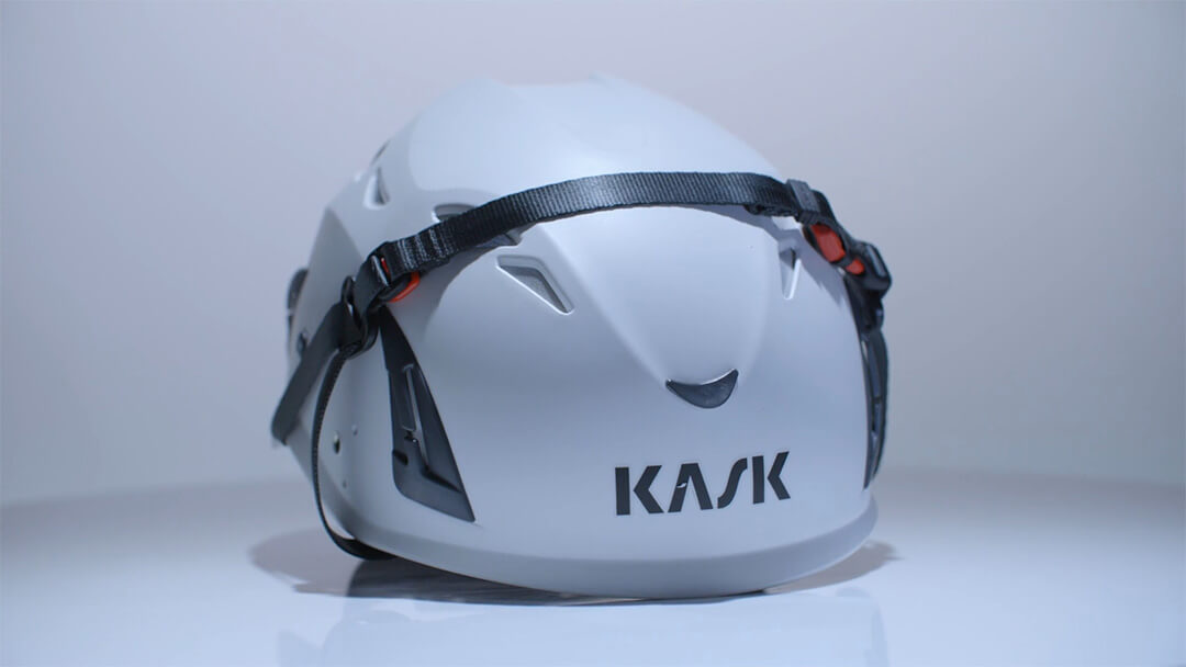Weisser Kask-Schutzhelm mit schwarzem Kinnriemen.