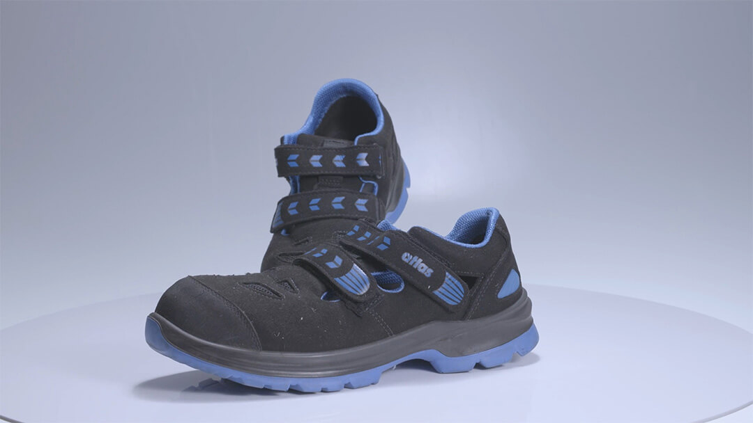 Schwarze Sicherheitsschuhe mit blauen Akzenten und Klettverschlüssen.