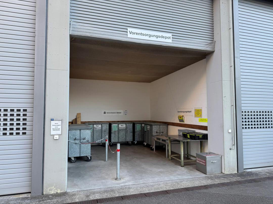 Offenes Depot mit mehreren Metallcontainern zum Sammeln von brennbarem Abfall und anderen Materialien.