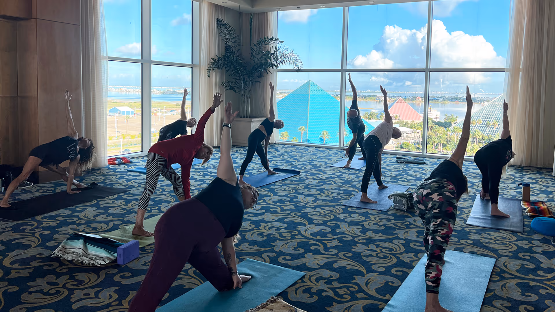 People doing yoga with Moody Gardens Pyramids in the background (Galveston, Texas)