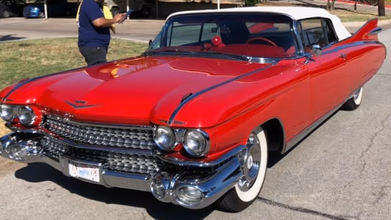 A vibrant red classic Cadillac car is parked on the street, with a person standing next to it in the background.

Moody Gardens, Galveston, Texas