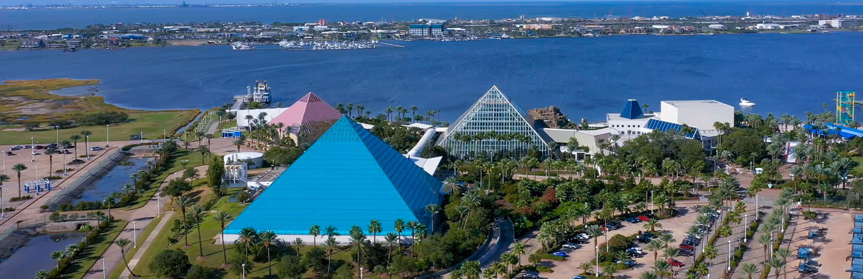 Aerial shot of Moody Gardens pyramids with water in the back