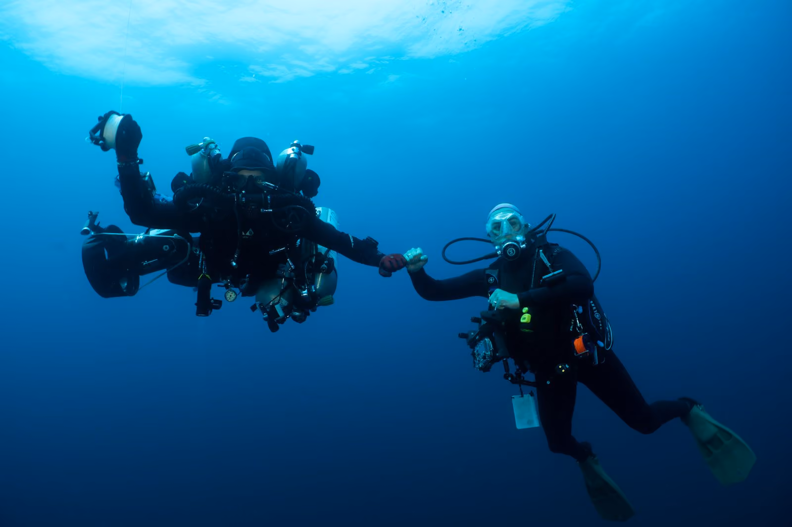 Divers meeting in the deep blue waters of the Gulf