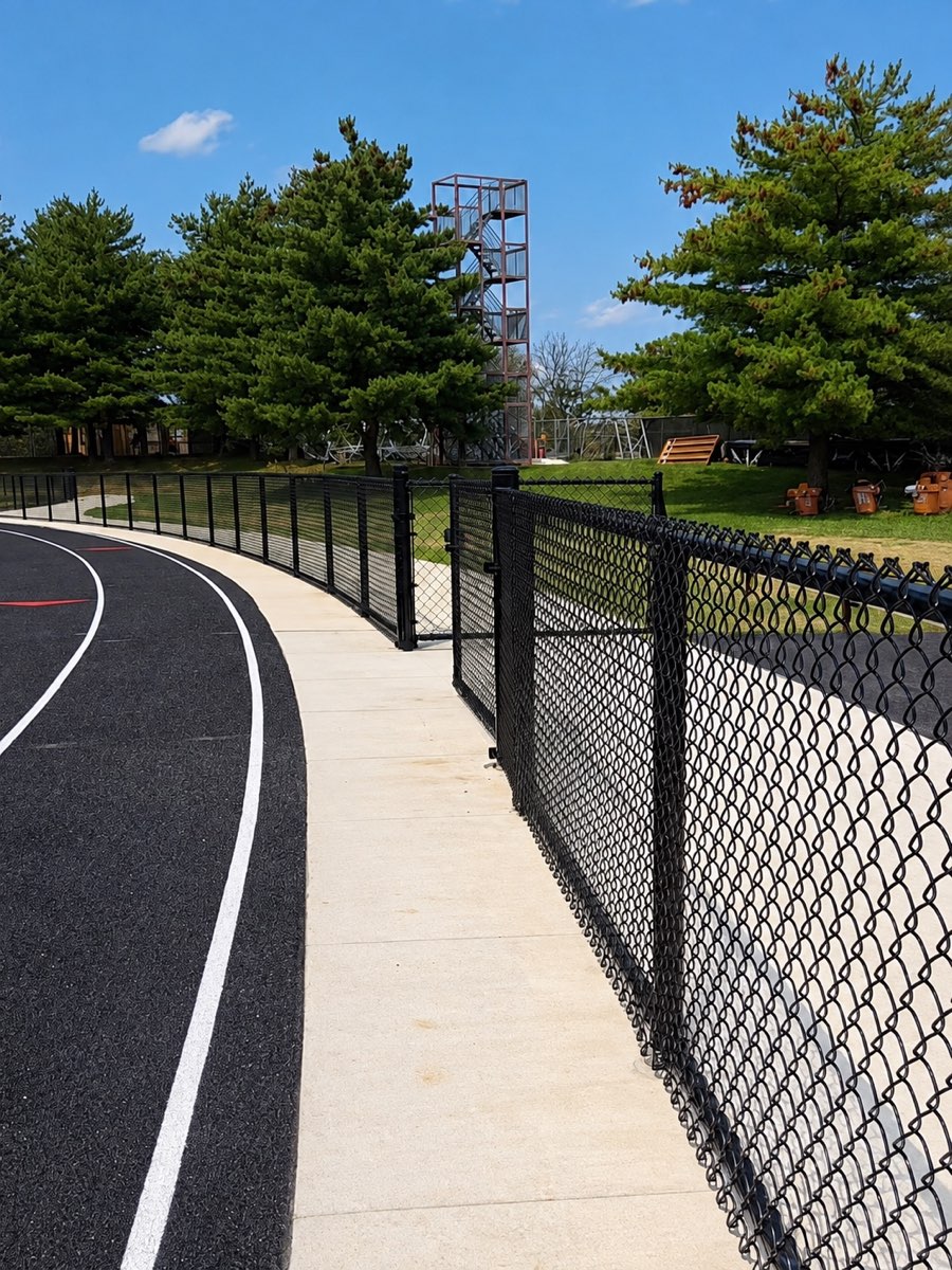 Black chain-link pedestrian gate beside the track at Paul Laurence Dunbar High School in Lexington, Kentucky