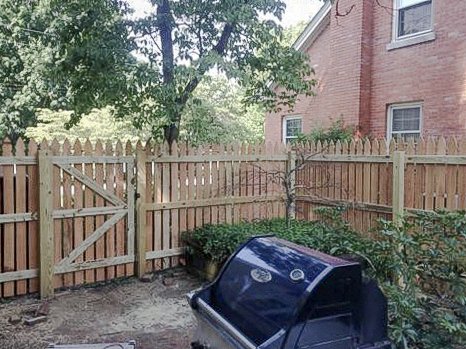 Cedar gate beside the brick house and outdoor grill in Midway.