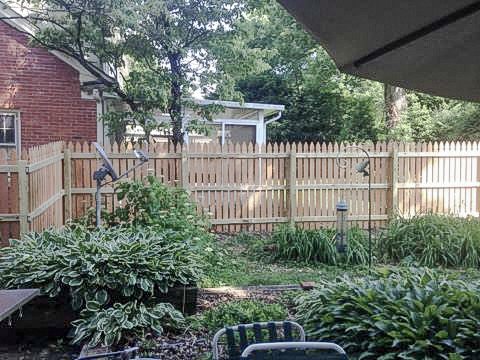 Cedar pickets framing a garden bed and lawn at the Midway home.
