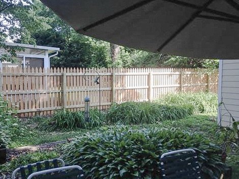 Interior cedar fence run bordering a planted garden in Midway, Kentucky.