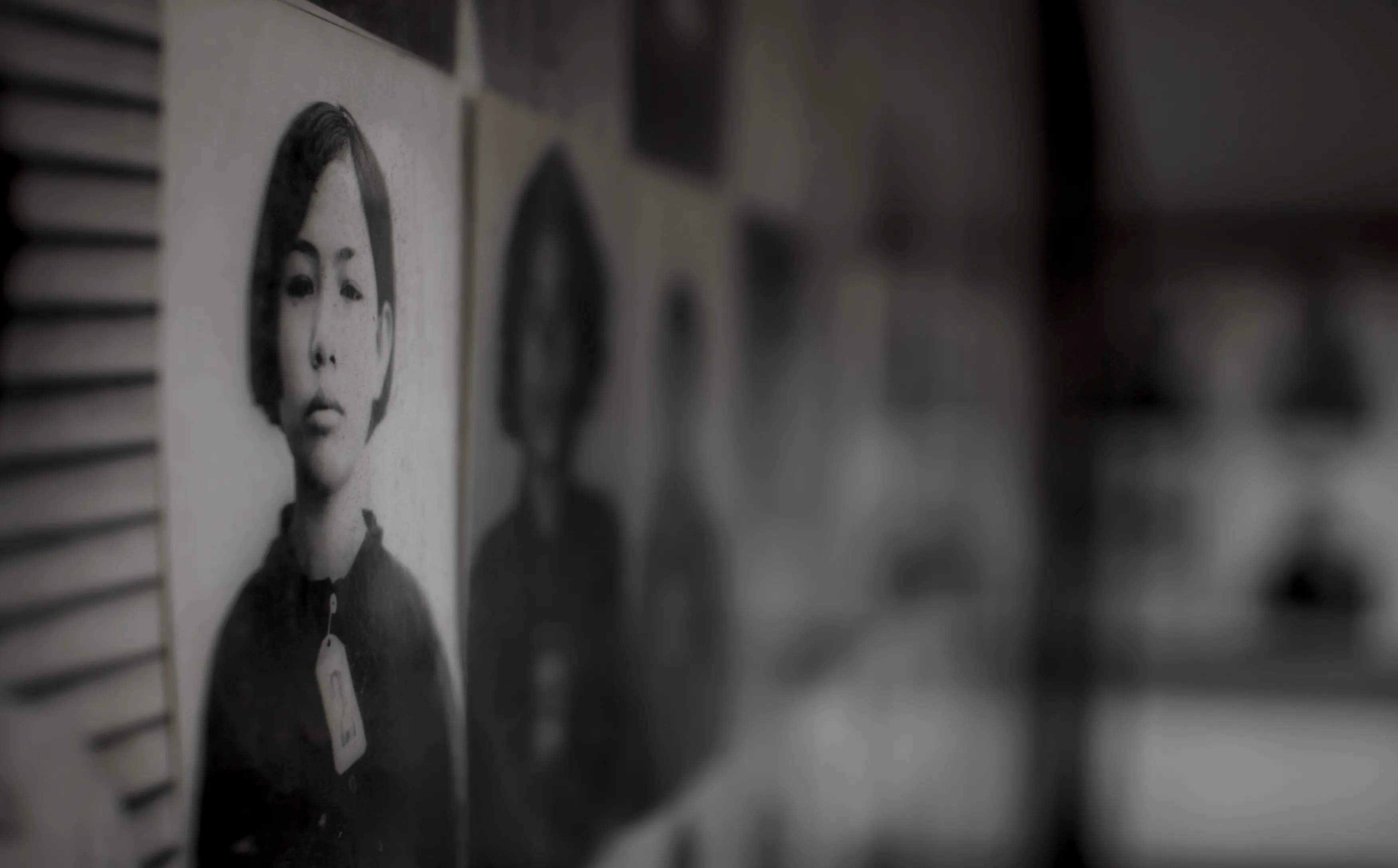 Wall of black-and-white archival portraits at the Tuol Sleng genocide memorial in Phnom Penh