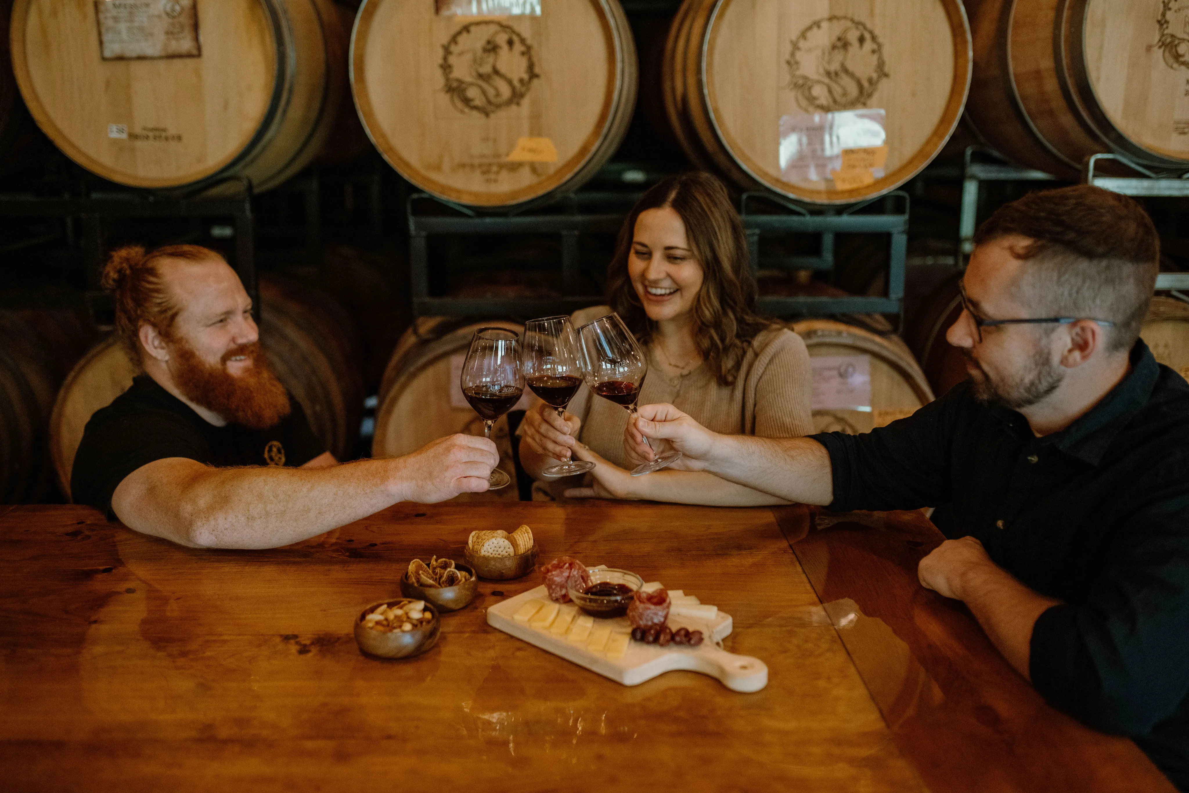 Guests enjoying a summer wine tasting with Cellar Beast wine bottles and small bites