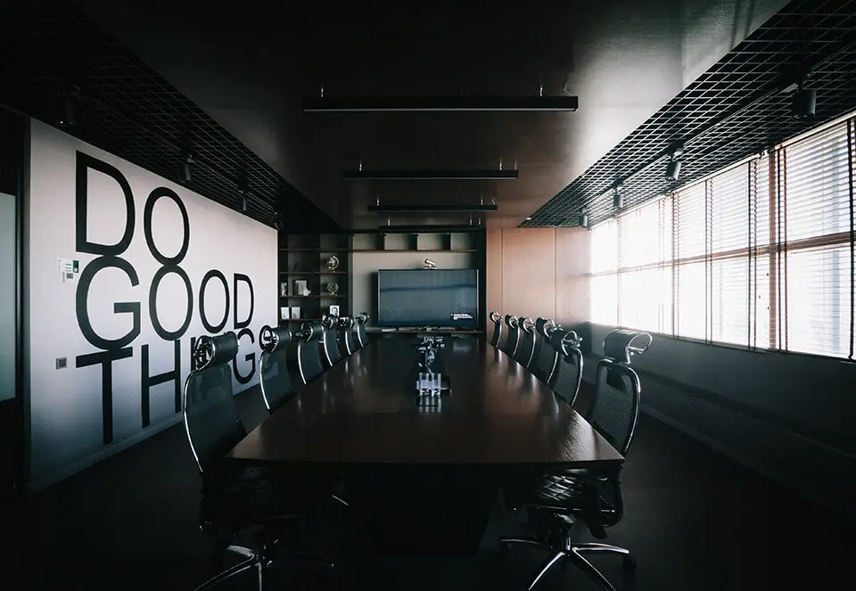 An empty conference room with the words "Do Good Things" written on the wall
