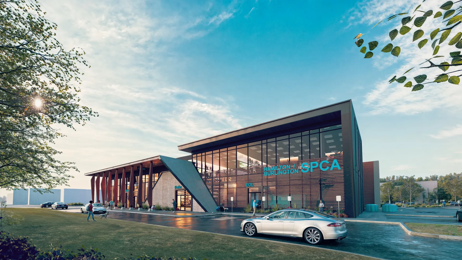 Modern Hamilton Burlington SPCA building with large glass windows, cars parked outside, and people walking on a sunny day.