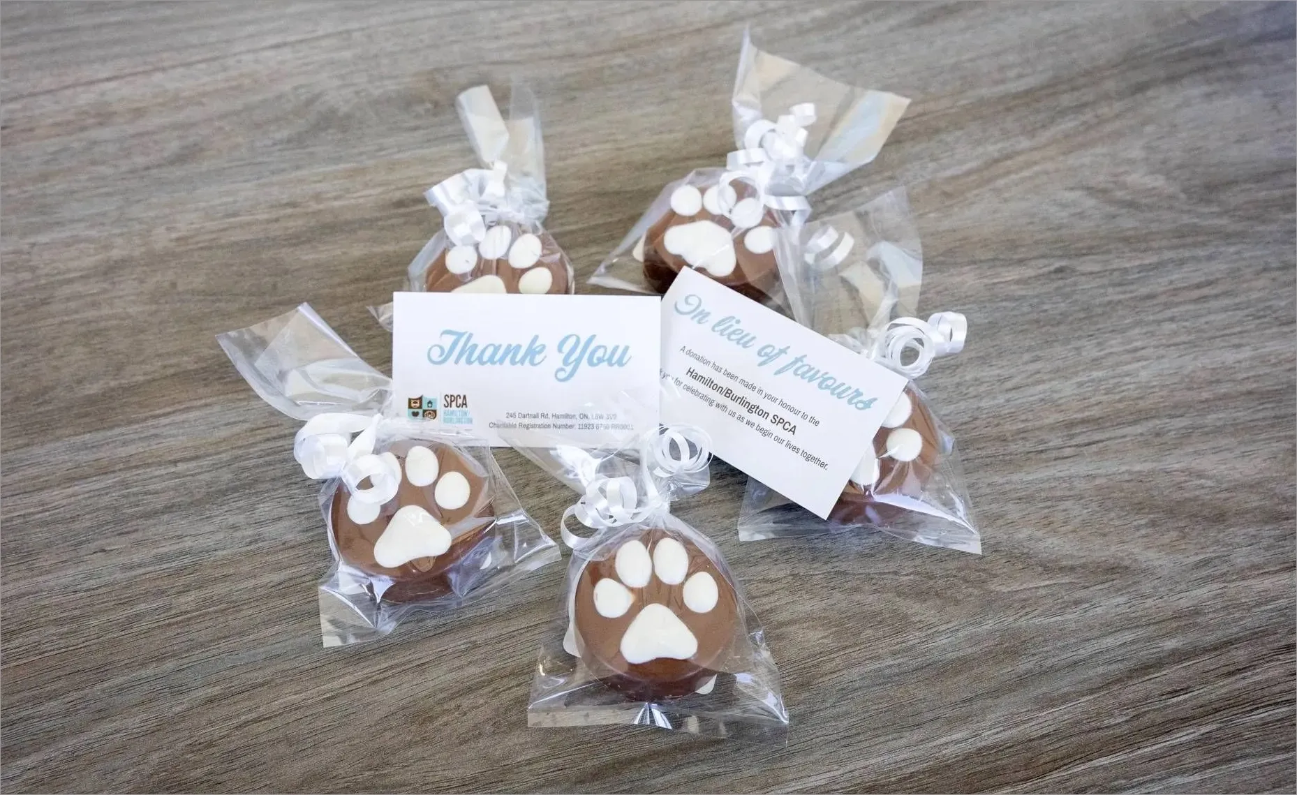 Five paw print chocolates individually wrapped with thank you and favor cards from Hamilton/Burlington SPCA.