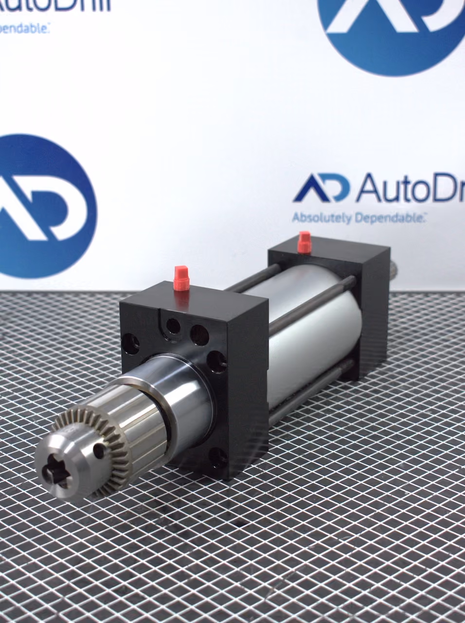 Non-stroking pneumatic drill component with metal chuck and black housing on a grid surface.