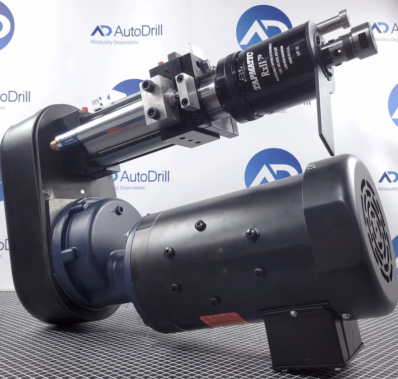 Close-up of a black industrial Tapmatic R&L T10 tapping machine motor on a grid surface.