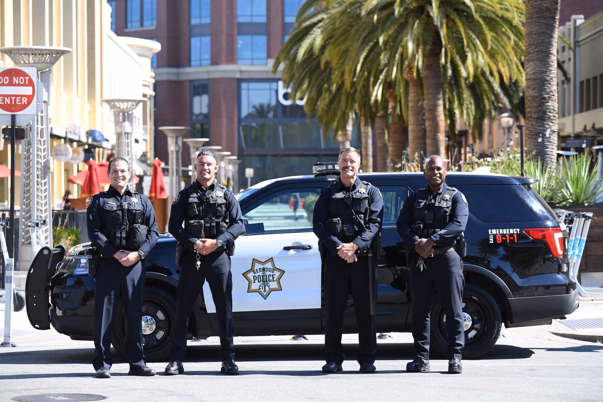 4 officers standing in front of police car