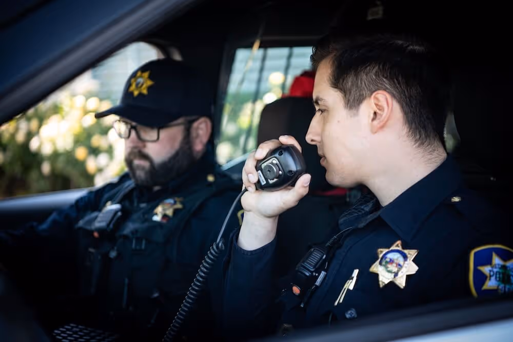 2 male officers in the car talking on the radio