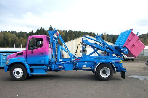 Western Cascade Container Stellar Container Carrier ECCR shown subframed for small Hooklift on Stellar Hooklift with custom features and Hedstrom Poly Front Load container in custom colors