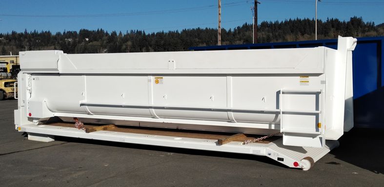 Western Cascade Container white radius wall highlift door box secured to flatbed for hooklift for shipping
