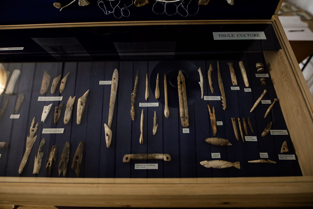 Wooden ancient tools and artifacts labeled in a display case under the title Thule Culture.